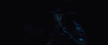 Movie still from “Jane Got a Gun” (2015), directed by Gavin O'Connor – A man wearing a black hat and a leather jacket; Close Up shot, Over the shoulder angle