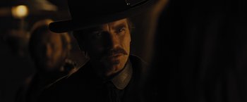 Movie still from “Jane Got a Gun” (2015), directed by Gavin O'Connor – A person wearing a cowboy hat; Close Up shot, Over the shoulder angle