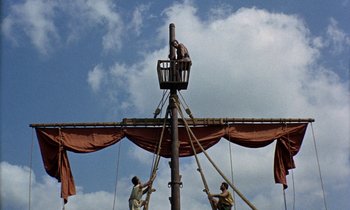 Movie still from “Jason and the Argonauts” (1963), directed by Don Chaffey – Two men are working on a wooden structure; Extreme Wide shot, Low angle
