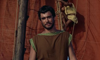 Movie still from “Jason and the Argonauts” (1963), directed by Don Chaffey – A man wearing a brown and green shirt and standing in front of a tree; Medium shot, Low angle