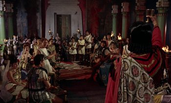 Movie still from “Jason and the Argonauts” (1963), directed by Don Chaffey – A group of people sitting in a large room; Wide shot, High angle