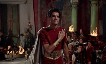 Movie still from “Jason and the Argonauts” (1963), directed by Don Chaffey – A man in a red and gold outfit standing in front of a group of people; Medium shot, Over the shoulder angle