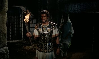 Movie still from “Jason and the Argonauts” (1963), directed by Don Chaffey – A man dressed as a roman soldier holding a torch; Medium shot, High angle