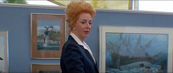 Movie still from “Jaws 3-D” (1983), directed by Joe Alves – An older woman standing in front of some paintings; Close Up shot, Low angle