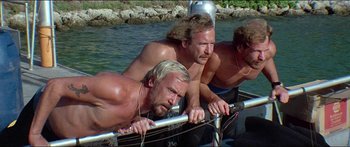 Movie still from “Jaws 3-D” (1983), directed by Joe Alves – A group of men on a boat in the water; Medium shot, Low angle