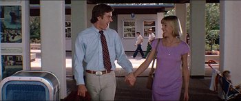 Movie still from “Jaws 3-D” (1983), directed by Joe Alves – A man and a woman holding hands while walking down a street; Medium shot, Low angle