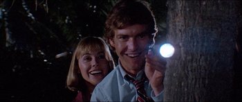 Movie still from “Jaws 3-D” (1983), directed by Joe Alves – A man and a woman smile while holding a flashlight; Close Up shot, Low angle