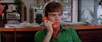 Movie still from “Jaws 3-D” (1983), directed by Joe Alves – A man holding a phone up to his ear; Close Up shot, Low angle