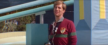 Movie still from “Jaws 3-D” (1983), directed by Joe Alves – A man in a red and green striped shirt holding a camera; Close Up shot, Low angle