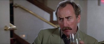 Movie still from “Jaws 3-D” (1983), directed by Joe Alves – An older man with a mustache is holding a glass of wine; Close Up shot, Low angle