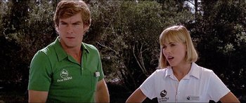 Movie still from “Jaws 3-D” (1983), directed by Joe Alves – A man and a woman standing next to each other in front of trees; Close Up shot, Low angle