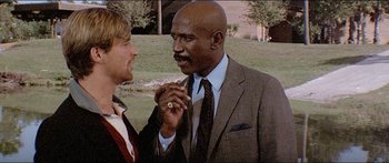 Movie still from “Jaws 3-D” (1983), directed by Joe Alves – A man in a suit talking to a woman in a suit and tie; Close Up shot, Over the shoulder angle