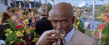 Movie still from “Jaws 3-D” (1983), directed by Joe Alves – A man in a suit and tie holding a glass of wine; Close Up shot, Low angle