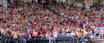 Movie still from “Jaws 3-D” (1983), directed by Joe Alves – A crowd of people sitting in bleachers with their hands raised; Wide shot, High angle