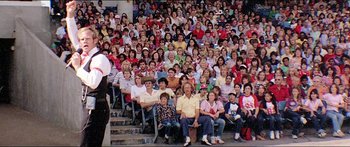 Movie still from “Jaws 3-D” (1983), directed by Joe Alves – A large group of people sitting on bleachers in a stadium; Wide shot, High angle