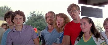 Movie still from “Jaws 3-D” (1983), directed by Joe Alves – A group of people standing next to each other in a park; Medium shot, Low angle