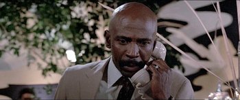 Movie still from “Jaws 3-D” (1983), directed by Joe Alves – A man in a suit and tie talking on a phone; Close Up shot, Low angle