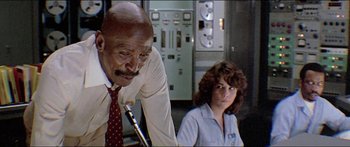 Movie still from “Jaws 3-D” (1983), directed by Joe Alves – A man and a woman sitting next to each other in front of an electrical panel; Medium shot, Low angle