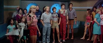 Movie still from “Jaws 3-D” (1983), directed by Joe Alves – A group of people standing next to each other in a room; Medium shot, Low angle