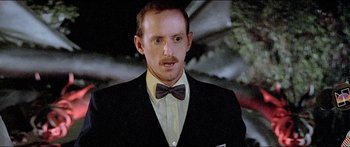 Movie still from “Jaws 3-D” (1983), directed by Joe Alves – A person wearing a suit and bow tie; Close Up shot, Low angle