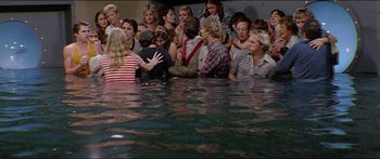 Movie still from “Jaws 3-D” (1983), directed by Joe Alves – A group of people standing in a body of water; Wide shot, High angle