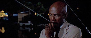 Movie still from “Jaws 3-D” (1983), directed by Joe Alves – A man with a beard is holding his hand to his mouth; Close Up shot, High angle