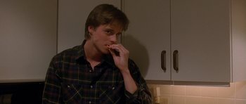 Movie still from “Jaws: The Revenge” (1987), directed by Joseph Sargent – A man in a plaid shirt is eating a sandwich; Close Up shot, Over the shoulder angle