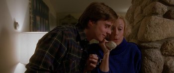 Movie still from “Jaws: The Revenge” (1987), directed by Joseph Sargent – A man and a woman talking on a phone; Medium shot, Low angle