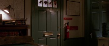 Movie still from “Jaws: The Revenge” (1987), directed by Joseph Sargent – A fire extinguisher is mounted to the side of the door; Medium shot, Over the shoulder angle