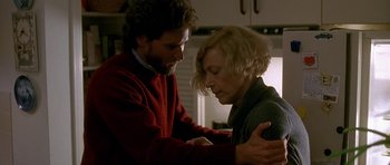 Movie still from “Jaws: The Revenge” (1987), directed by Joseph Sargent – A man and a woman are holding hands in a kitchen; Close Up shot, Low angle