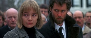 Movie still from “Jaws: The Revenge” (1987), directed by Joseph Sargent – A man and a woman standing next to each other in a crowd; Close Up shot, Over the shoulder angle