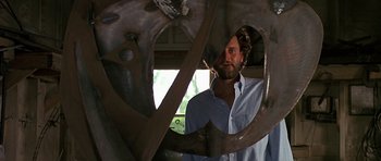 Movie still from “Jaws: The Revenge” (1987), directed by Joseph Sargent – A man standing in front of a large metal object; Medium shot, Low angle
