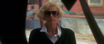 Movie still from “Jaws: The Revenge” (1987), directed by Joseph Sargent – A woman with blonde hair wearing sunglasses and a black shirt; Close Up shot, Low angle
