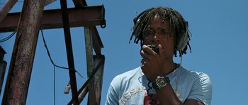 Movie still from “Jaws: The Revenge” (1987), directed by Joseph Sargent – A man with dreads talking on a cell phone; Close Up shot, Low angle