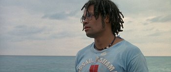 Movie still from “Jaws: The Revenge” (1987), directed by Joseph Sargent – A man with dreads is looking out at the ocean; Close Up shot, Low angle