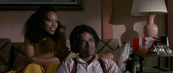 Movie still from “Jaws: The Revenge” (1987), directed by Joseph Sargent – A man sitting next to a woman on a couch; Medium shot, Low angle