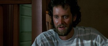 Movie still from “Jaws: The Revenge” (1987), directed by Joseph Sargent – A person with a beard looking at the camera; Close Up shot, Low angle