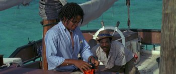 Movie still from “Jaws: The Revenge” (1987), directed by Joseph Sargent – Two men sitting on a boat in the water; Medium shot, High angle