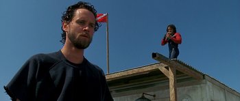 Movie still from “Jaws: The Revenge” (1987), directed by Joseph Sargent – A man and a woman standing on top of a building; Medium shot, Low angle