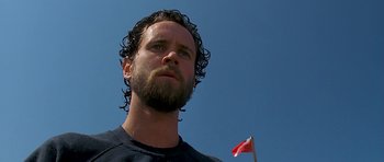 Movie still from “Jaws: The Revenge” (1987), directed by Joseph Sargent – A person with a flag in the background; Close Up shot, Low angle