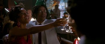 Movie still from “Jaws: The Revenge” (1987), directed by Joseph Sargent – A man wearing a green party hat is holding a glass of wine; Close Up shot, Low angle