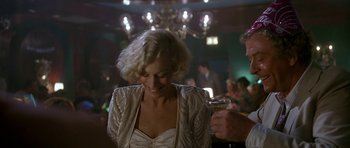 Movie still from “Jaws: The Revenge” (1987), directed by Joseph Sargent – A woman in a white dress holding a wine glass; Medium shot, Over the shoulder angle