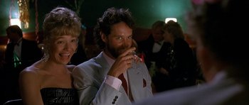 Movie still from “Jaws: The Revenge” (1987), directed by Joseph Sargent – A man in a suit and tie smoking a cigarette; Close Up shot, Over the shoulder angle