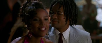 Movie still from “Jaws: The Revenge” (1987), directed by Joseph Sargent – A man and a woman posing for a picture at an event; Close Up shot, Over the shoulder angle