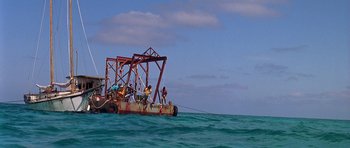 Movie still from “Jaws: The Revenge” (1987), directed by Joseph Sargent – A group of people standing on top of a boat in the ocean; Extreme Wide shot, High angle