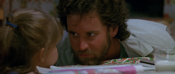 Movie still from “Jaws: The Revenge” (1987), directed by Joseph Sargent – A man with a long beard looking down at a child; Close Up shot, Over the shoulder angle