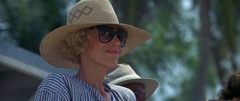 Movie still from “Jaws: The Revenge” (1987), directed by Joseph Sargent – A woman wearing a straw hat and sunglasses; Close Up shot, Low angle
