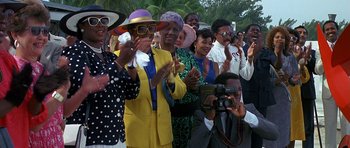 Movie still from “Jaws: The Revenge” (1987), directed by Joseph Sargent – A group of people standing next to each other and clapping; Medium shot, Low angle