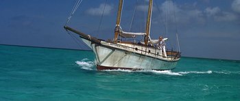 Movie still from “Jaws: The Revenge” (1987), directed by Joseph Sargent – A man on a sail boat in the ocean; Wide shot, High angle