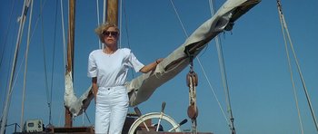 Movie still from “Jaws: The Revenge” (1987), directed by Joseph Sargent – A woman standing next to a sail on a sail boat; Medium shot, Low angle